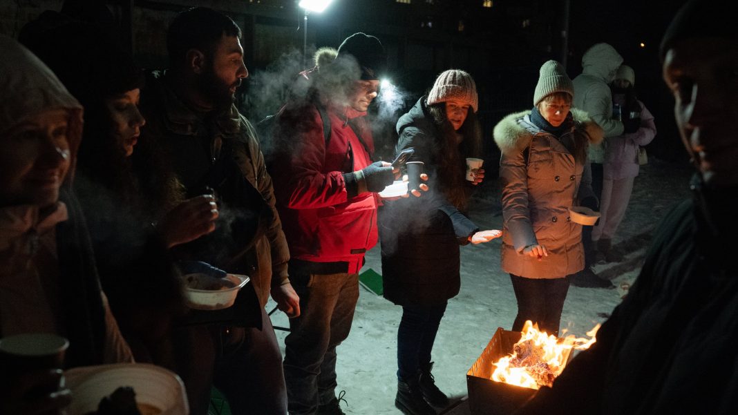 У Києві люди гріються біля вогнища на вулиці через відсутність світла та опалення у квартирах внаслідок російських атак. Фото: Gettyimages